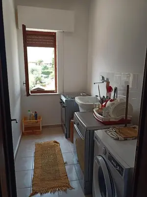 a bathroom with a sink and a washing machine at Aura azzurra in Carini