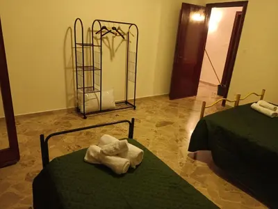 a room with two beds with towels on them at Aura azzurra in Carini