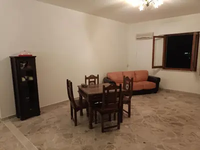 a living room with a table and chairs and a couch at Aura azzurra in Carini