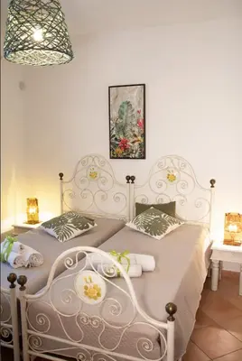 a bedroom with two beds and a picture on the wall at Anemos Apartment - Villa Sole in Macari
