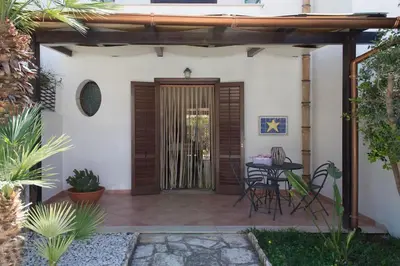 a patio with a wooden door and a table at Anemos Apartment - Villa Stella in Macari