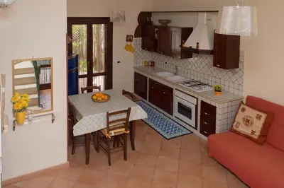 a small kitchen with a table and a couch at Anemos Apartment - Villa Stella in Macari