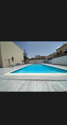 a large blue swimming pool in a building at La perla marina casa vacanza in San Vito lo Capo