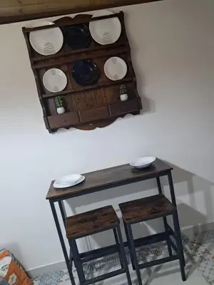 a table with two stools and plates on a wall at Maddy Luxury Apartment in Palermo