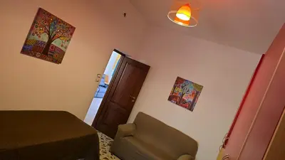 a bedroom with a bed and a chair and a door at Casa U' Rittu Filu in Bagheria