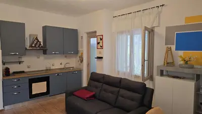 a living room with a couch and a kitchen at Casa U' Rittu Filu in Bagheria
