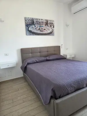 a bedroom with a bed with a purple bedspread at I Vicini di Ballarò in Palermo