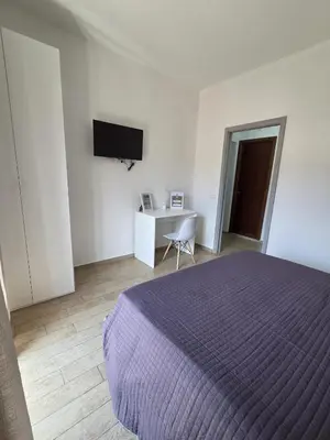 a bedroom with a bed and a desk and a tv at I Vicini di Ballarò in Palermo