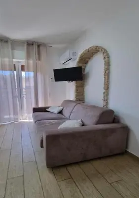 a living room with a couch and a mirror at I Vicini di Ballarò in Palermo