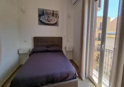 a bed in a bedroom with a balcony at I Vicini di Ballarò in Palermo
