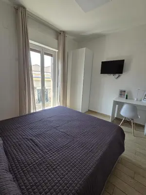 a bedroom with a bed and a window and a desk at I Vicini di Ballarò in Palermo