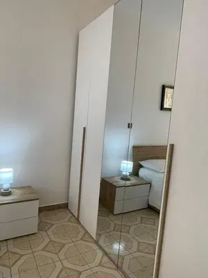 a reflection of a bedroom with a bed and a mirror at Casa MIUZZA in Isola delle Femmine