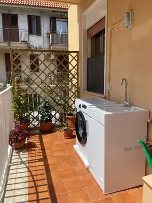 a washing machine on a patio with a building at Casa MIUZZA in Isola delle Femmine