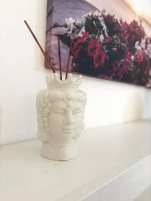 a white vase sitting on a shelf next to flowers at Casa MIUZZA in Isola delle Femmine