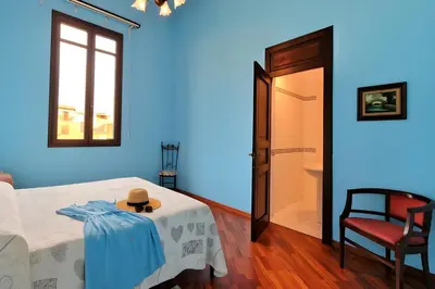 a blue room with a bed with a hat on a table at Casa De Gasperi in Castellammare del Golfo