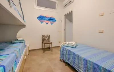 a bedroom with two beds and a chair in it at Beautiful Apartment In Balestrate in Balestrate