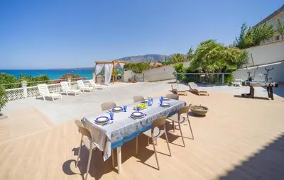 a table and chairs on a patio near the ocean at 3 Bedroom Lovely Apartment In Trappeto in Trappeto