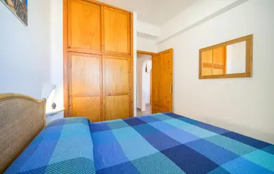 a bedroom with a blue bed and a wooden cabinet at 3 Bedroom Lovely Apartment In Trappeto in Trappeto