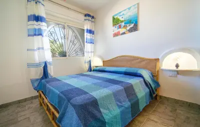 a bedroom with a bed with a blue plaid blanket at 3 Bedroom Lovely Apartment In Trappeto in Trappeto