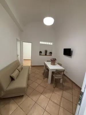 a living room with a couch and a table at Helios Apartaments in Cinisi