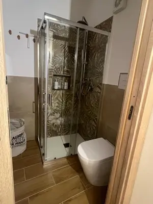 a bathroom with a toilet and a glass shower at Infiniti noi home in Palermo