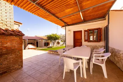 a patio with a white table and chairs at Villa Casty with private pool in Trabia