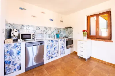 a kitchen with blue and white wallpaper at Villa Casty with private pool in Trabia