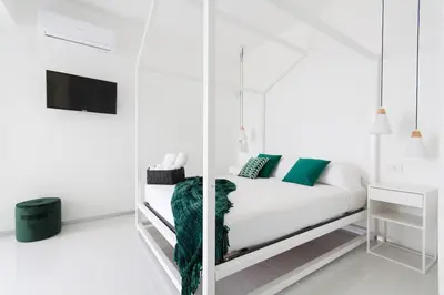 a white room with a bed and a mirror at White Luxury Villa by Le Dhome Sicily in Partinico