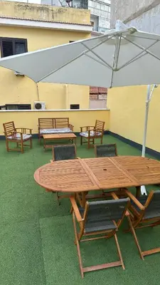 a wooden table and chairs with a large white umbrella at Mahalo in Palermo