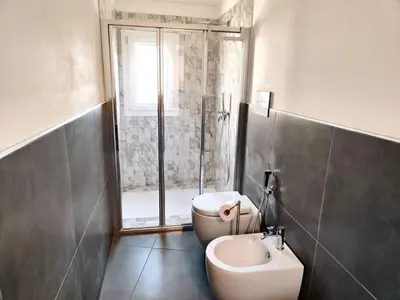 a bathroom with a shower and a toilet and a sink at QASA apartment with terrace, Palermo center in Palermo