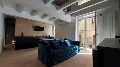 a living room with a couch with blue pillows at AntoX3 in Palermo