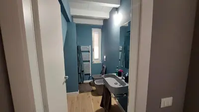 a bathroom with blue walls and a sink and toilets at AntoX3 in Palermo