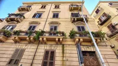 a tall building with potted plants on the balconies at AntoX3 in Palermo