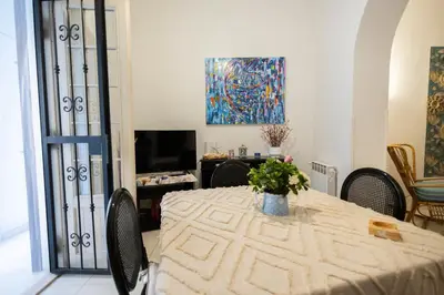 a dining room with a table with chairs and a painting at Plaza Del Mar Casa vacanza Mondello in Palermo