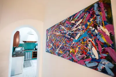 a painting hanging on a wall in a kitchen at Plaza Del Mar Casa vacanza Mondello in Palermo