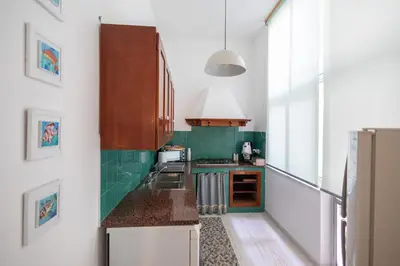 a small kitchen with green and white walls at Plaza Del Mar Casa vacanza Mondello in Palermo