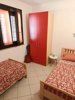 a bedroom with two beds and a red cabinet at Relax beach San Vito lo Capo in San Vito lo Capo