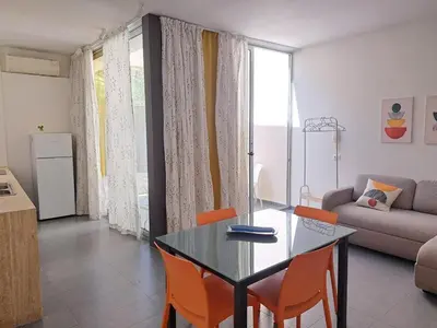 a living room with a glass table and orange chairs at CasaLavinaro in Castellammare del Golfo