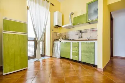 a kitchen with green cabinets and a large window at La Casetta del Vicolo in Palermo