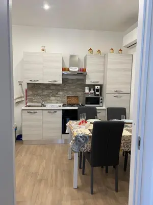 a kitchen with a dining table and a kitchen with white cabinets at Casa Annachiara in Palermo