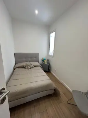 a white bedroom with a bed and a window at Casa Annachiara in Palermo