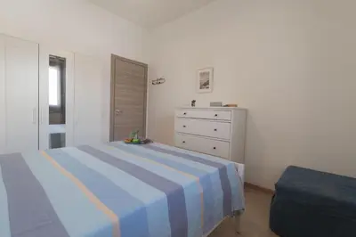 a bedroom with a blue and white bed and a dresser at Appartamento La Loggetta a pochi metri dalla spiaggia di San Vito Lo Capo in San Vito lo Capo