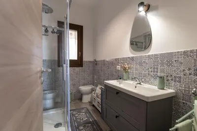 a bathroom with a sink and a toilet and a mirror at Appartamento La Loggetta a pochi metri dalla spiaggia di San Vito Lo Capo in San Vito lo Capo