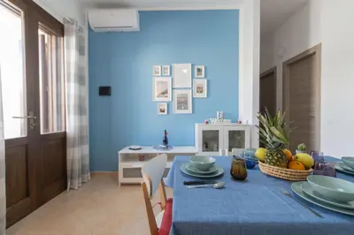 a blue dining room with a blue table and chairs at Appartamento La Loggetta a pochi metri dalla spiaggia di San Vito Lo Capo in San Vito lo Capo