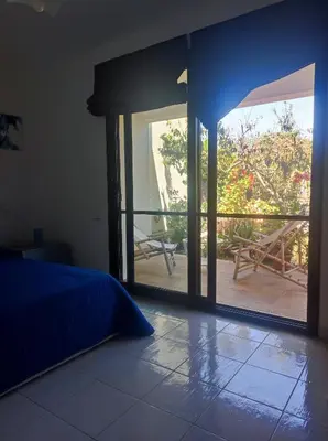 a bedroom with a bed and a sliding glass door at Cale e Calle in Terrasini