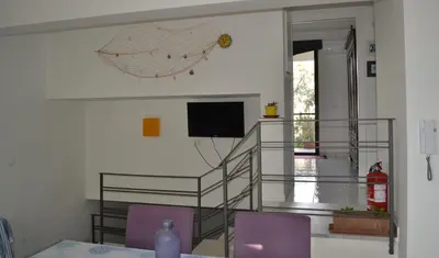 a dining room with two purple chairs and a television at Cale e Calle in Terrasini