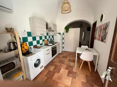 a kitchen with a washing machine and a table at Casa Fico D'India in Cinisi