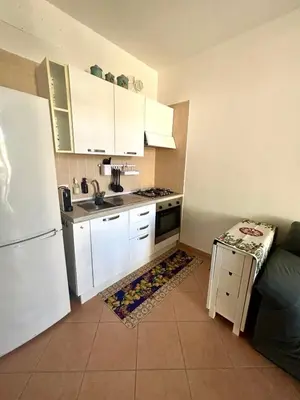 a kitchen with white cabinets and a white refrigerator at casa NiKa a 150 mt dal mare in Isola delle Femmine