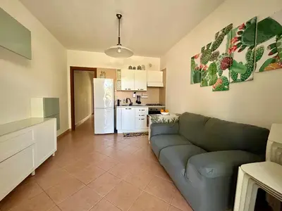 a living room with a couch and a kitchen at casa NiKa a 150 mt dal mare in Isola delle Femmine