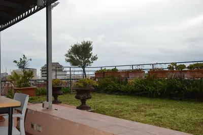 a patio with a table and chairs and a garden at Appartamento con vista in Palermo